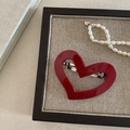 Close-up of a red heart-shaped resin hair clip with silver metal clasp on a tray - Burgundy