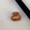 Detailed view of an amber cellulose acetate hair claw with France Handmade gold lettering - Milk Brown Stripes