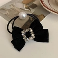 Detail van de zwarte fluwelen haarstrik met kristallen hart en witte parelaccenten - Vierkante Strass Stijl