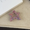 Détail d'une pince à cheveux étoile colorée en laine avec texture peluche et ressort - Rose