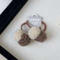 Détail de pinces à cheveux à pompons marron et crème avec leur carte de support - Élastique Cheveux Balle Marron