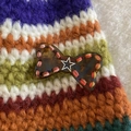 Close-up of tortoise shell bow hair clip with hand-stitched edges and silver star detail - Brown