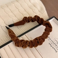 Close-up of brown velvet pleated headband with soft texture on a display stand - Ginger Yellow Velvet Headband