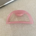Dettaglio molletta per capelli rosa in acetato con design a semicerchio su tessuto beige - Rosa