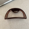 Dettaglio del fermaglio per capelli a semicerchio con logo dorato France Handmade - Cioccolato