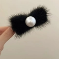 Detalle de una pinza para el pelo con lazo de piel sintética y una gran perla central - Negro