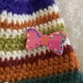 Handmade knitted hair clip featuring colorful striped wool yarn and a pink bow charm - Rose Red