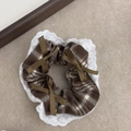 Detail view of brown plaid scrunchie with white lace edges and olive green bows - Coffee Plaid
