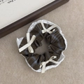 Close-up of vintage plaid hair scrunchie with lace edges and delicate white ribbon bows - Blue and Brown Plaid