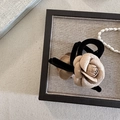 Gros plan d'une pince à cheveux camélia beige avec bordure en velours noir - Petite Pince Crabe Champagne