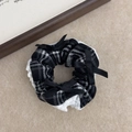 Vintage plaid scrunchie with white lace edges and small black satin bows on grey background - Black Plaid