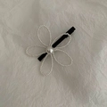 Dettaglio del fermaglio per capelli a fiore con petali di perle bianche e base nera a becco d'anatra - Fiore di Perla