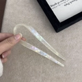 U-shaped acetate hair pin with pearlescent finish held against a minimalist background - Mermaid Color