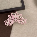 Detailed close-up of a pink acetate flower hair claw clip with crystal rhinestones - Pink