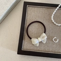 Detail of elegant white pearlescent bow hair tie with gold France Handmade lettering - Iridescent White