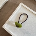 Dettaglio del ciondolo a cuore in resina verde oliva sull'elastico per capelli - Verde