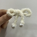 Dettaglio del fermaglio per capelli a fiocco bianco crema con eleganti perle e lana a maglia - Bianco Sporco
