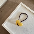 Detalle de un colgante de corazón en resina amarilla traslúcida con goma marrón - Amarillo