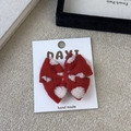 Detail of red knitted bow hair clip with white flower pattern on a white display card - Red Bow