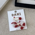 Detail view of handmade beige plush hair clip set with red pom-poms on display card - White Bow Pom Pom Style