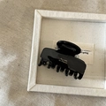 Close-up of black acetate hair claw clip with gold Barrette La France text engraving - Black
