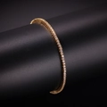Vista macro del bracciale tennis d'oro con zirconi da 2 mm su supporto espositivo nero - 7" / Oro