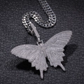 Macro-opname van een hiphop vlinderhanger met verzilvering en ingelegde zirkoon kristal - Kettingset / Zilverkleur En Staalkleurige Cubaanse Ketting
