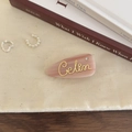 Nahaufnahme einer rosa Marmor Haarklammer aus Acetat mit Goldschrift und Perlenakzent - Rosa