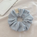 Detailed shot of light blue corduroy scrunchie with striped texture and brand label - Light Blue Zircon