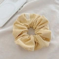 Detail showing cream corduroy scrunchie texture with a small woven label on soft fabric - Milky Yellow