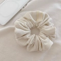 Close-up of cream-colored corduroy scrunchie with soft ribbed texture and a fabric label - Off-white