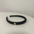 Détail d'un serre-tête en satin noir avec fermoir doré et logo fait main à l'intérieur - Noir