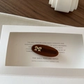 Macro detail of a dark brown oval hair clip with a delicate golden 3D bow ornament - Dark Brown