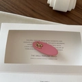 Detailed macro view of pink matte hair clip with golden metallic bow accent - Pink