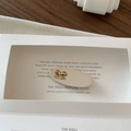 Beige oval hair clip featuring a gold metal bow detail in a vintage French style - Off-white