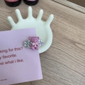 Gros plan sur la barrette à cheveux ours rose avec strass sur un support en céramique - Ours Rose Rouge