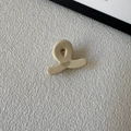 Detailweergave van handgemaakte beige haarclip van acetaat met merknaamgravure - Off-wit