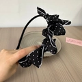 Close-up of a vintage black polka dot bow headband with white piping and layered fabric - Black