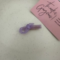 Detail view of a lavender purple resin bow hair clip with a golden metal duckbill clip - Purple