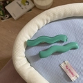 Detail of two green wavy acrylic hair clips with a smooth finish on a soft fabric background - Wavy Pattern (XY-1154) / Lake Green Series