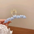 Dettaglio di molletta trasparente con cuori blu marmorizzati e molla in metallo oro - Blu