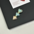 Detalle de horquilla de triple corazón con efecto holográfico en bandeja de exhibición - Green System