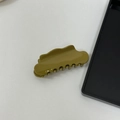 Dettaglio della molletta per capelli in acetato verde oliva con bordi ondulati su bianco - Verde Senape