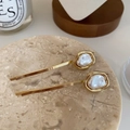 Detalle de pinzas para el cabello con perlas barrocas sobre bandeja de mármol vintage - Dorado