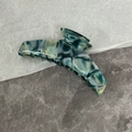 Dettaglio della molletta per capelli in acetato marmorizzato blu con logo dorato - Verde