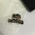 Close-up of marble acetate hair claw clip with golden Barrette la France logo - Milk Coffee