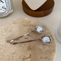 Perlas barrocas en clips de metal plateado sobre una bandeja de mármol beige - Plateado