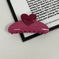 Macro detail of a high-gloss rose pink heart-shaped hair claw clip with rounded teeth - Rose Red