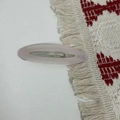 Macro shot of the Barrette La France lettering on a pink oval acetate hair clip - Light Pink