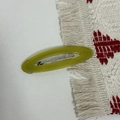 Macro detail of oval acetate hair clip in lime green with durable metal spring fastener - Grass Green